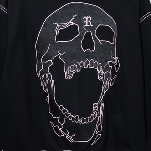 Close up of the back of a black zip hoodie showing a black embroidered skull outlined with pink embroidery