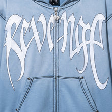 Load image into Gallery viewer, Close up of a treated and washed baby blue zip hoodie with white embroidered Revenge arch logo with black outline embroidery
